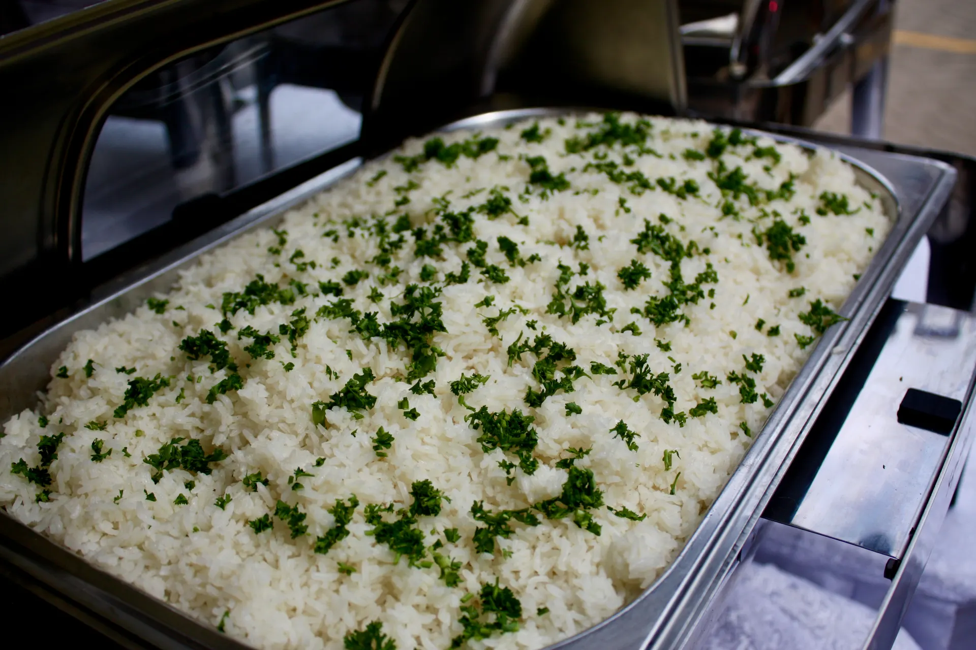Rice garnished with parsley in a chafing dish